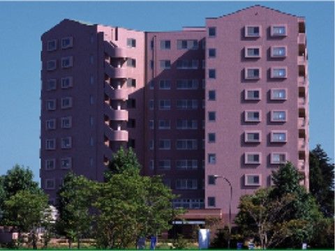 10階建ての外観は一般のマンションのような風貌である。深みのある暖色系の外壁に、居室の窓が規則的に並んでいる。