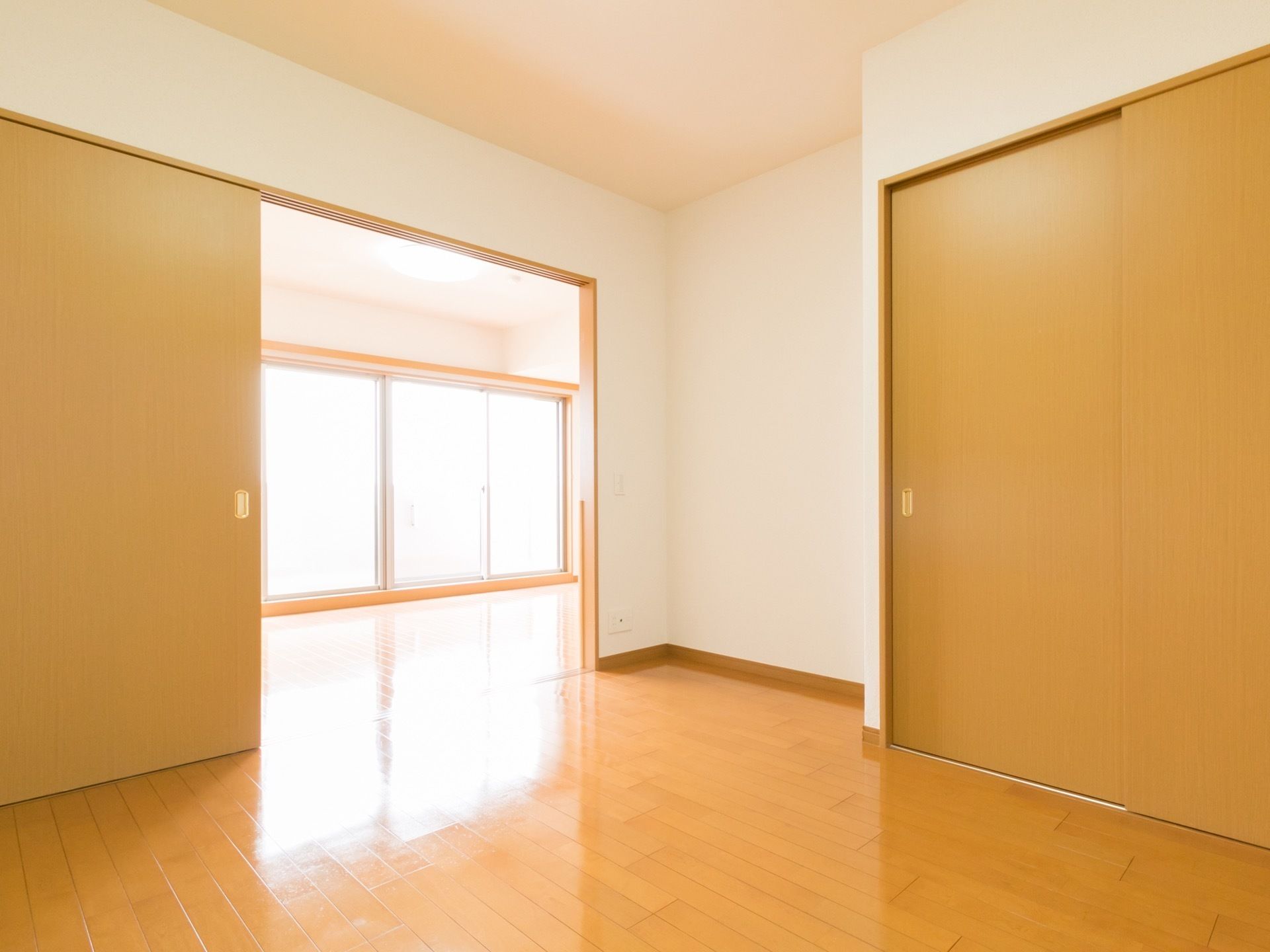 部屋のフローリング材と開き戸はいずれも木目調で、統一感のある内装である。窓からは光が差込み明るいのが特徴である。