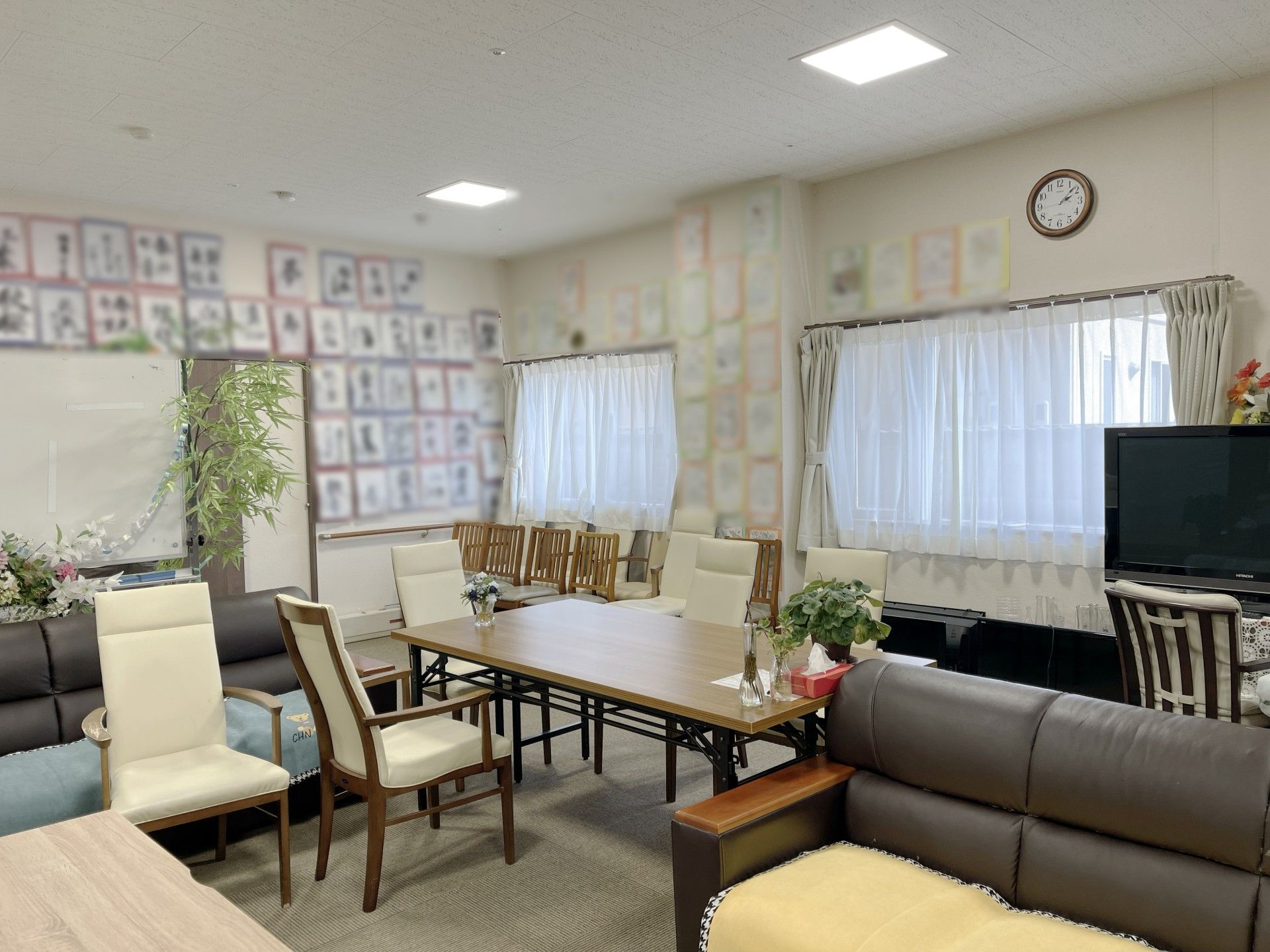 障子のある部屋で、男性の入居者様が和服を着て書道をしている様子