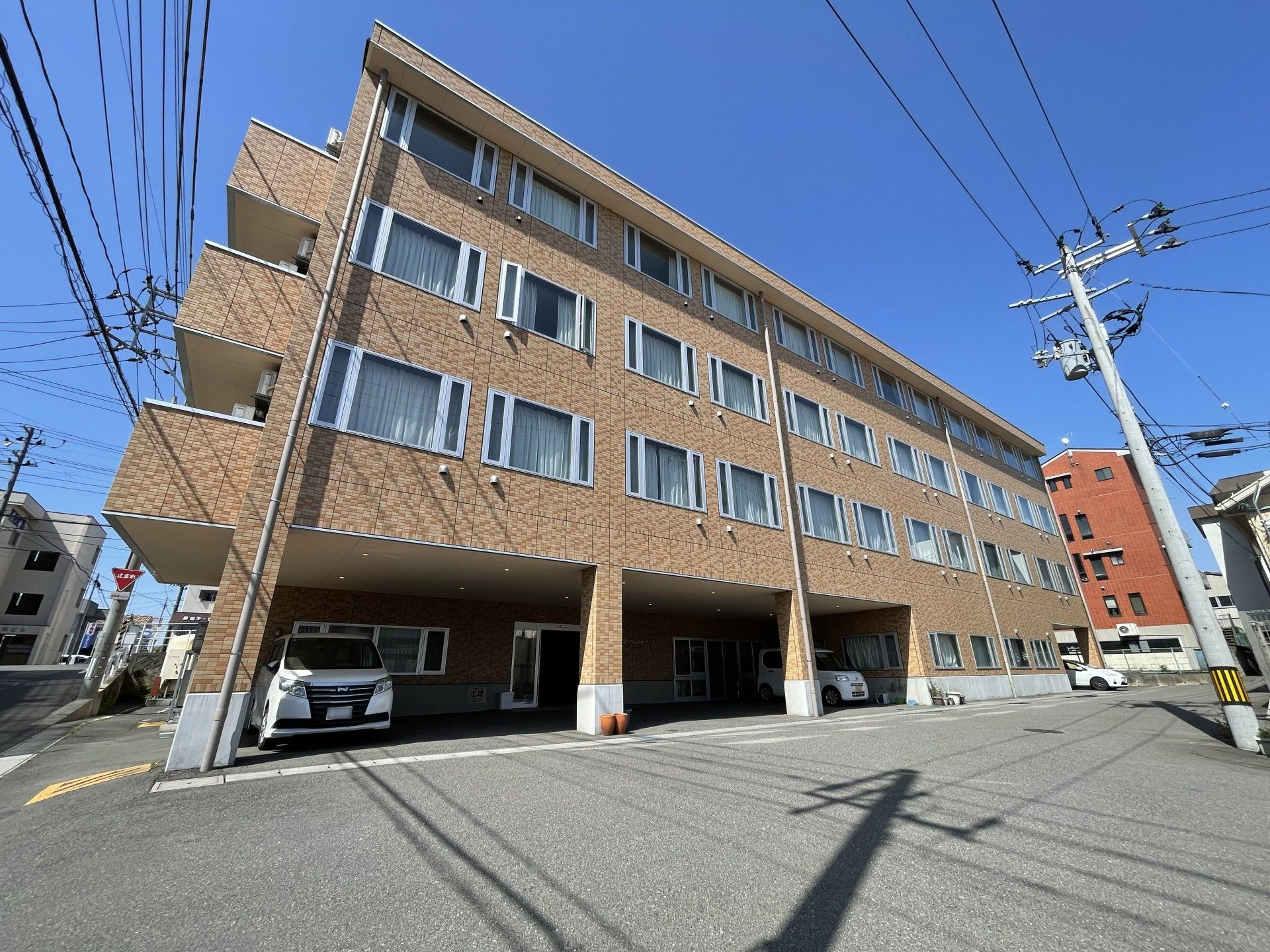 ベッドで横たわる入居者様を、笑顔で接しながら介助するスタッフ