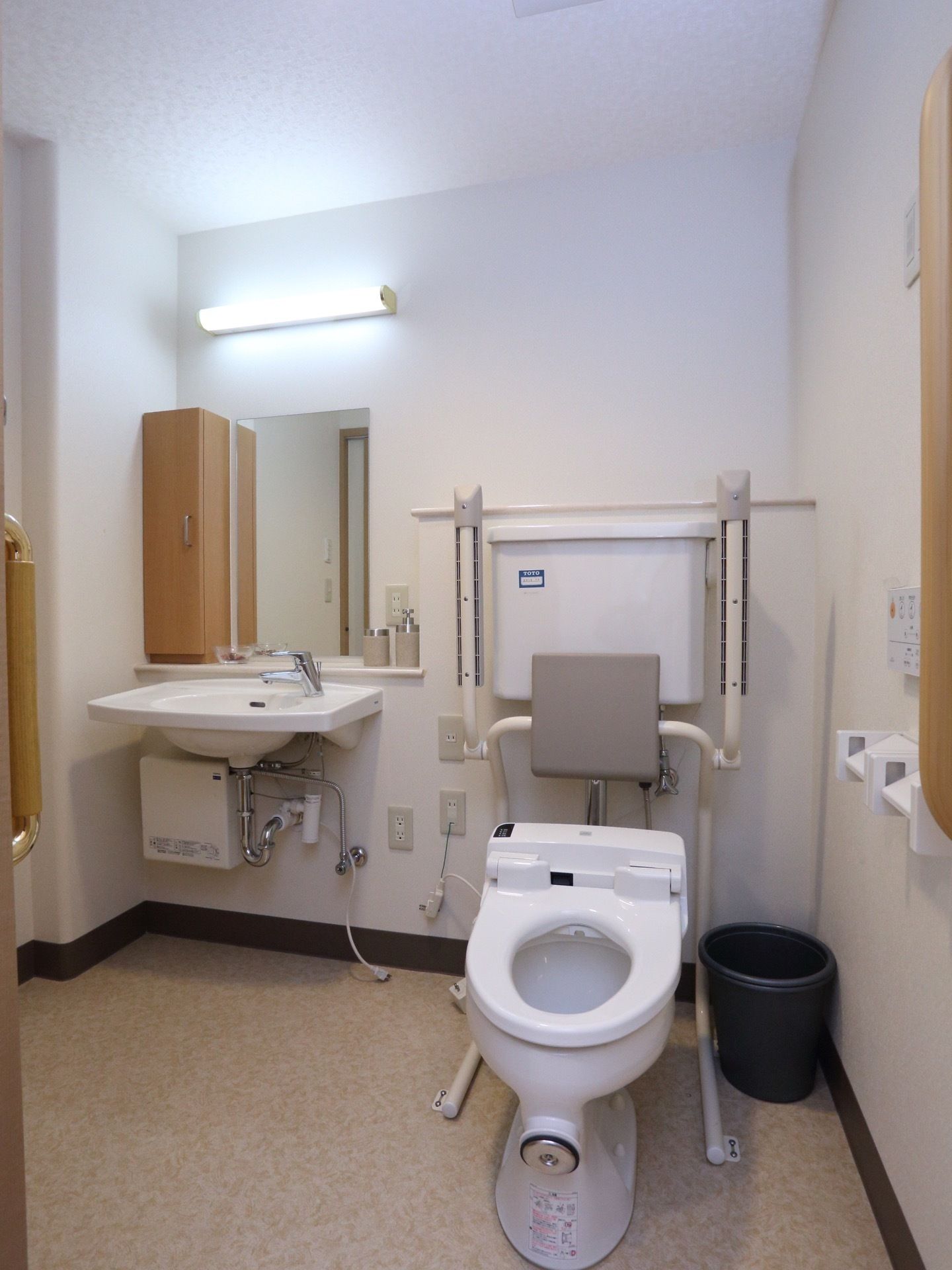 車椅子でも楽に入れるよう、トイレは十分な広さを備えている。壁には手すりと呼出ボタンが設置されている。