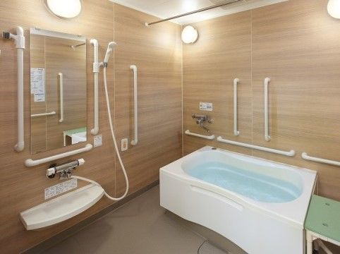 「朝霞ケアパークそよ風」の個別浴室。個別用の浴室にも、介助手すりや、シャワーチェアといったサポート器具が多い。