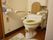 清潔感のあるトイレである。便器の両側にはしっかりとした手すりが設置されており、入居者様は安心して体を預けることができる。
