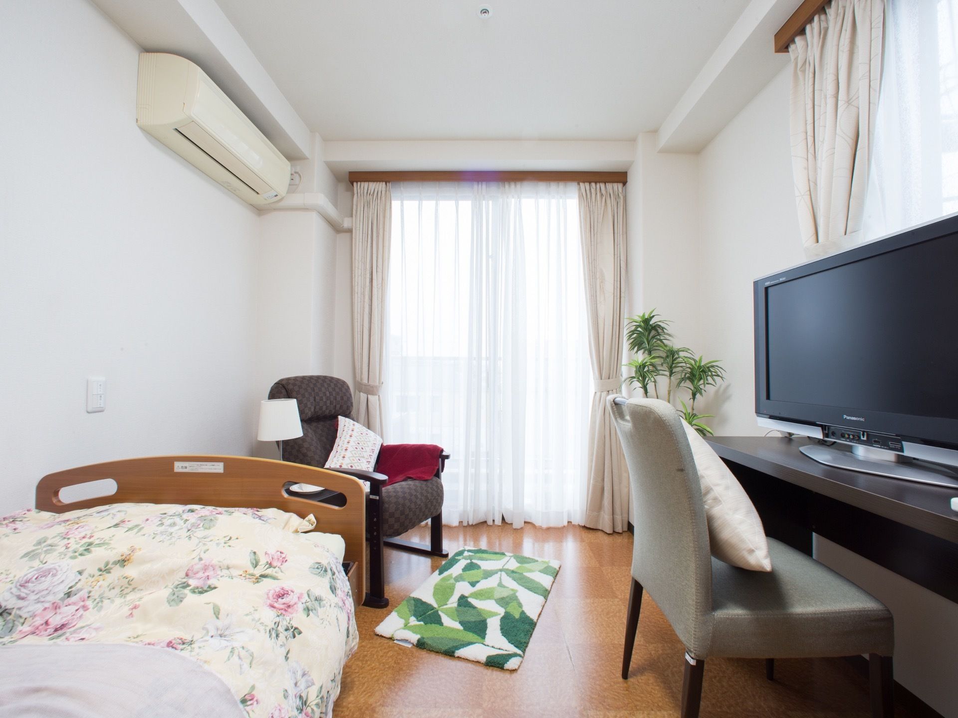フローリングの部屋に、ベッドとテレビ、椅子などが設置されている。窓は大きく日ざしがよく入るので明るい部屋となっている。