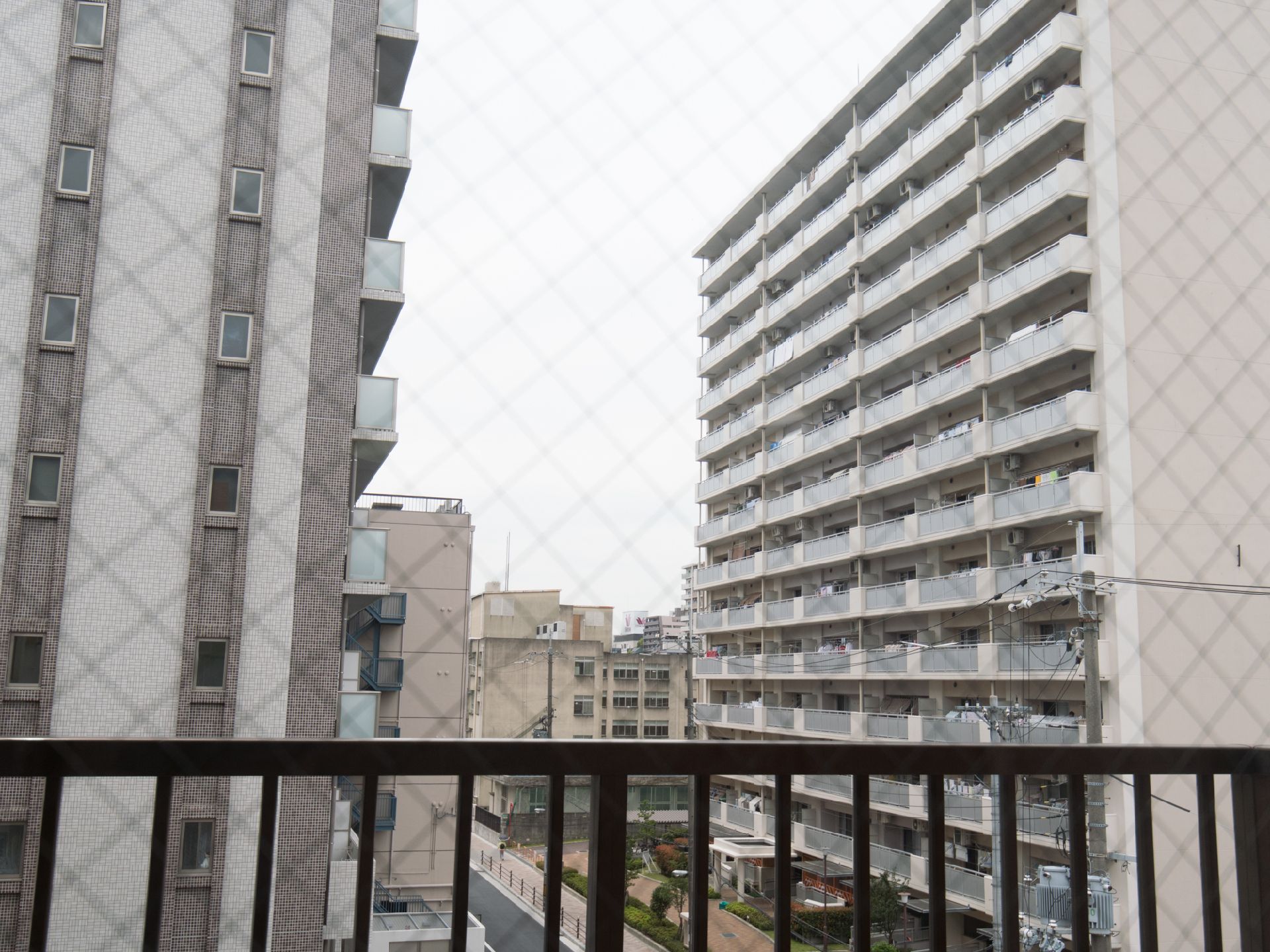 居室の窓は網入り窓になって万が一の時にガラスが飛び散るのを防止している。外には14階建てのマンションなどが見える。
