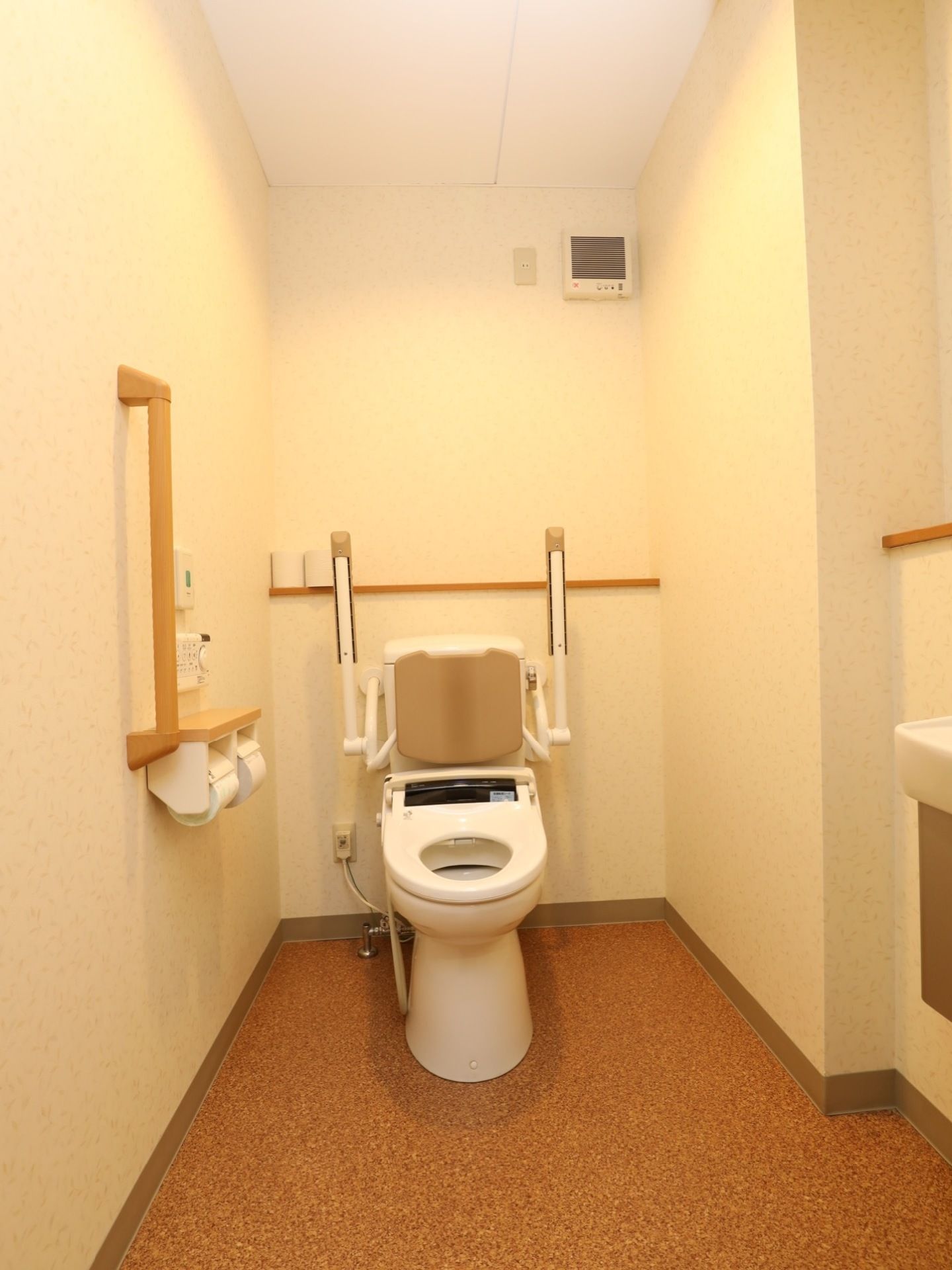 洋式のトイレには背もたれや可動式の肘掛けが備わっている。壁には手すりや緊急時呼び出しベルが設けられている。