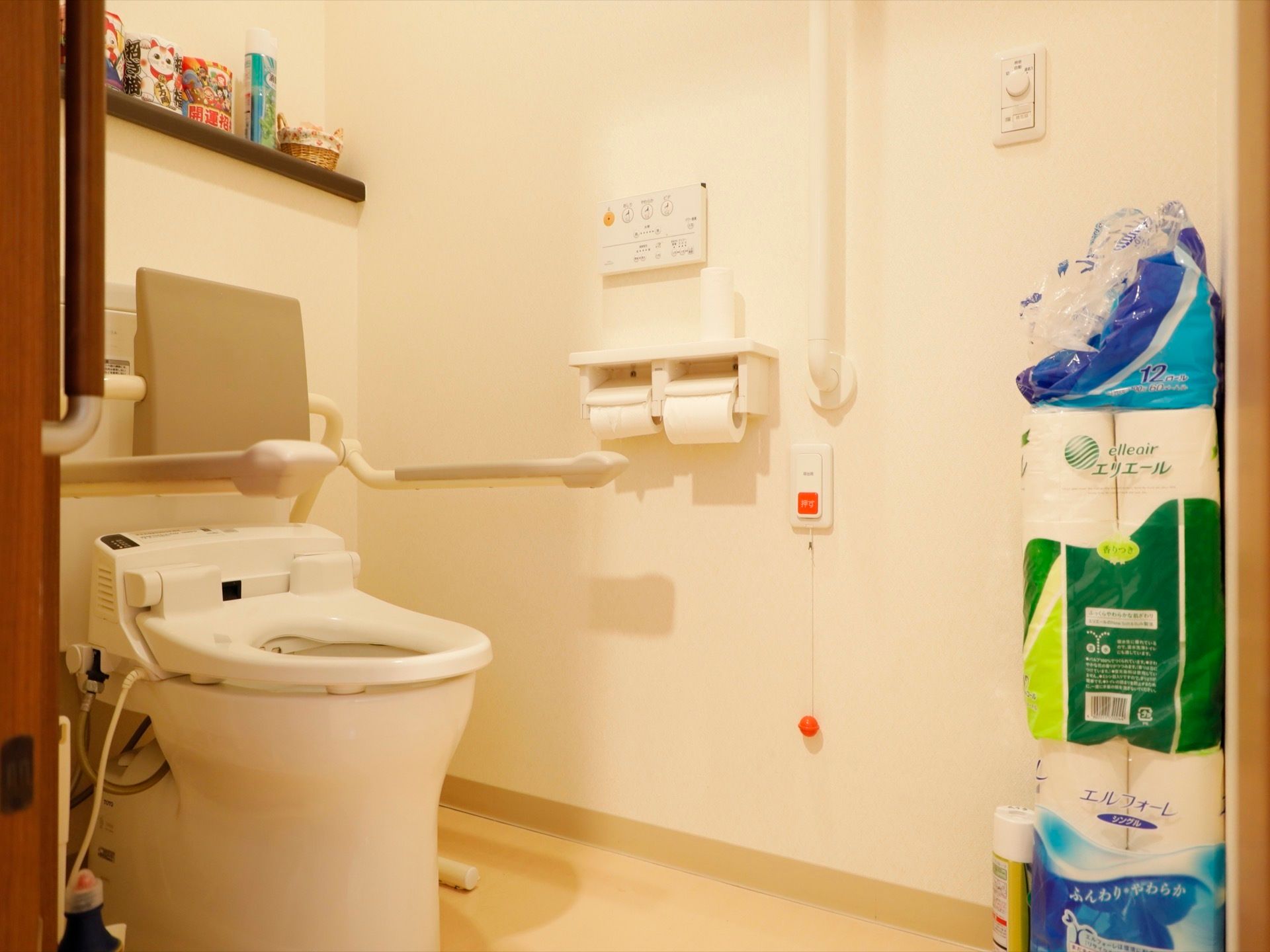 洋式便器が一据ある。手前にトイレットペーパーが積まれている。便器奥のカウンターには小物や、消臭スプレーが置かれている。