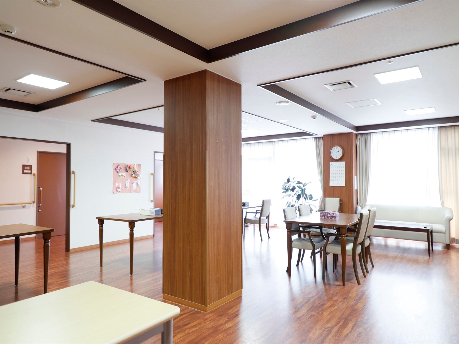 清潔感のある広い食堂である。観葉植物が置かれてある。各テーブル間には十分な距離があり、転倒や怪我の防止に努めている。