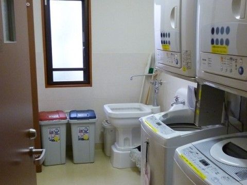 「所沢グループリビングそよ風」の洗濯室。上の棚には乾燥機、下には洗濯機を設けている。