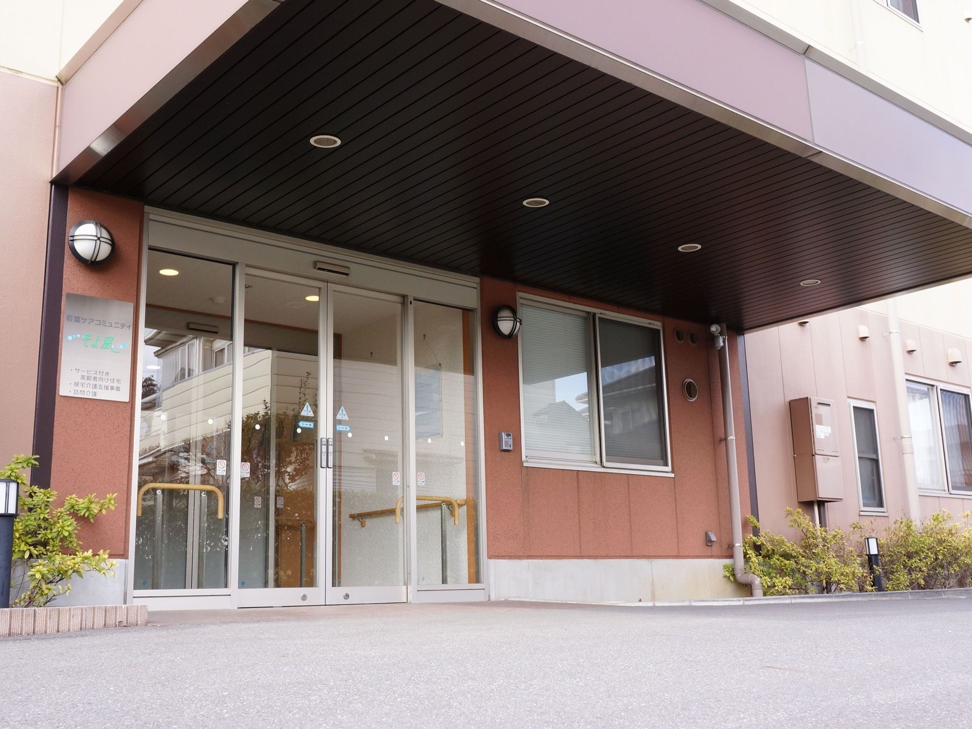 大きなひさしが特徴のエントランスである。玄関ドアには、利便性の高い自動ドアが採用されている。壁にインターホンや照明が設置されている。