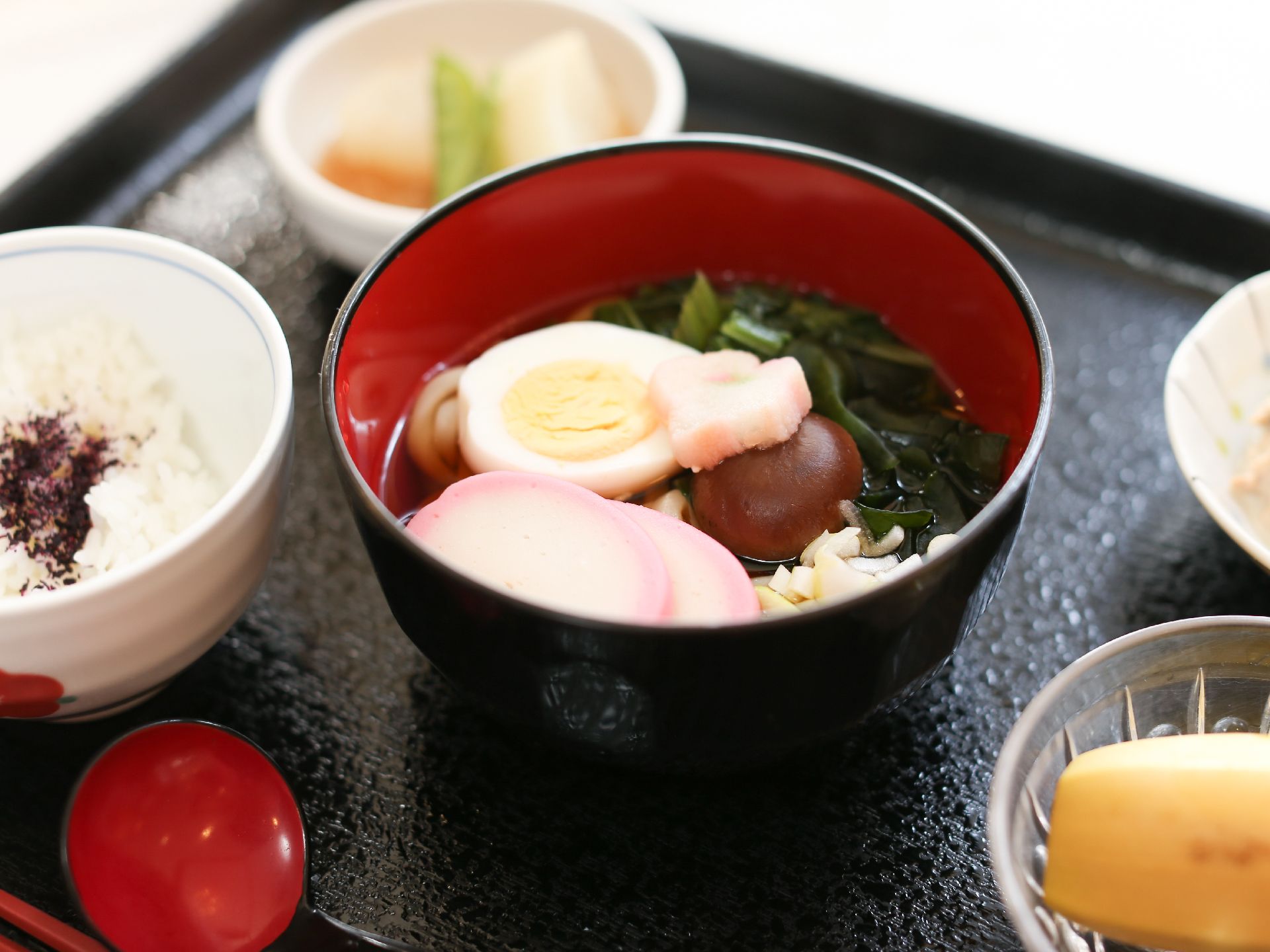 うどんにはゆでたまごやかまぼこ、わかめなどが添えられており、一品でたくさんの栄養素が摂れるようになっている。果物もついている。