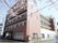 「相模原ケアコミュニティそよ風」桜の花びらが映える建物外観