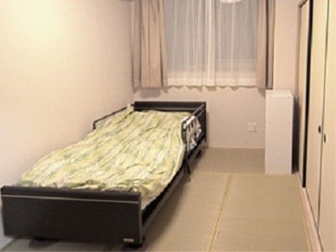 ベッド、冷蔵庫、エアコンが完備されているこぢんまりとしたひとり用居室