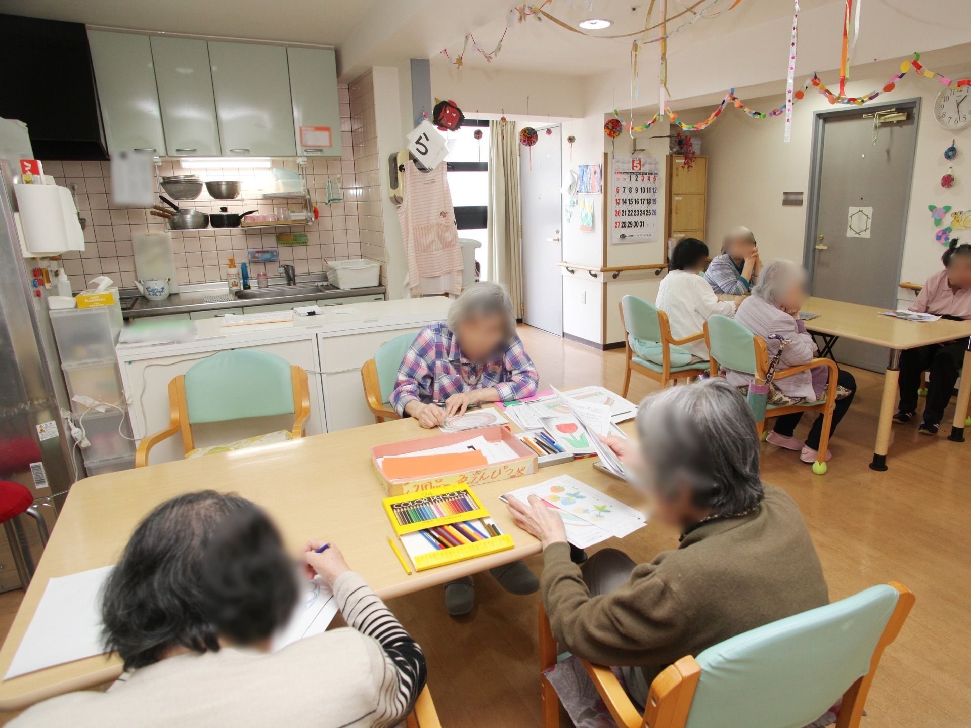 キッチンが備えられた共有スペース。壁には装飾が飾られており、入居者様がそれぞれで絵を描いたり、談話を楽しんだりしている。