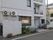住宅地に馴染むように白い壁で、施設の名前が書かれた看板が貼り出されている。窓が有り、それぞれの部屋にバルコニーが設けられている。