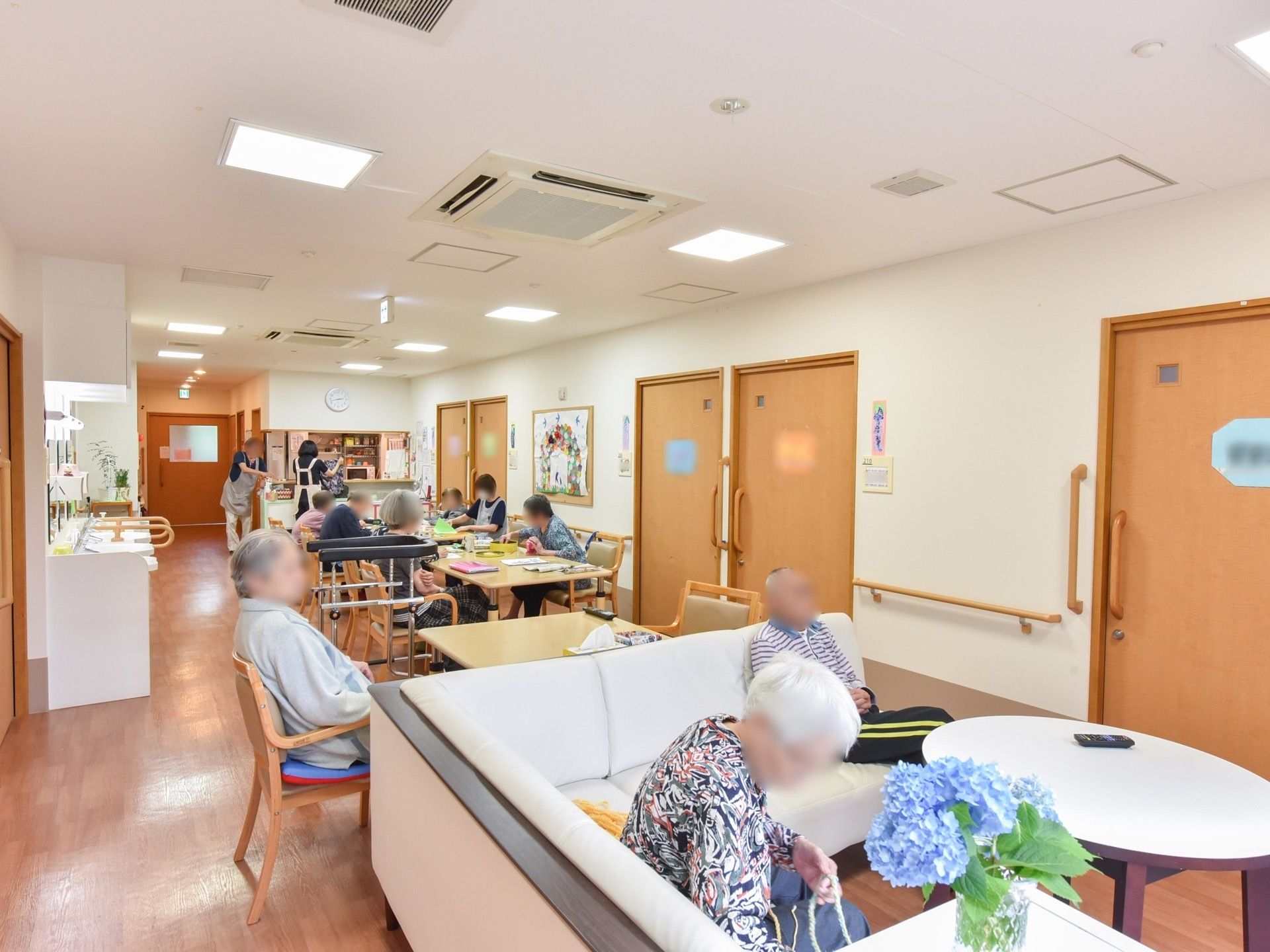 縦に長いスペースにテーブルと椅子をセットにして並べ、横側に楕円のテーブルとソファを配置している。壁際に洗面台を備えている。