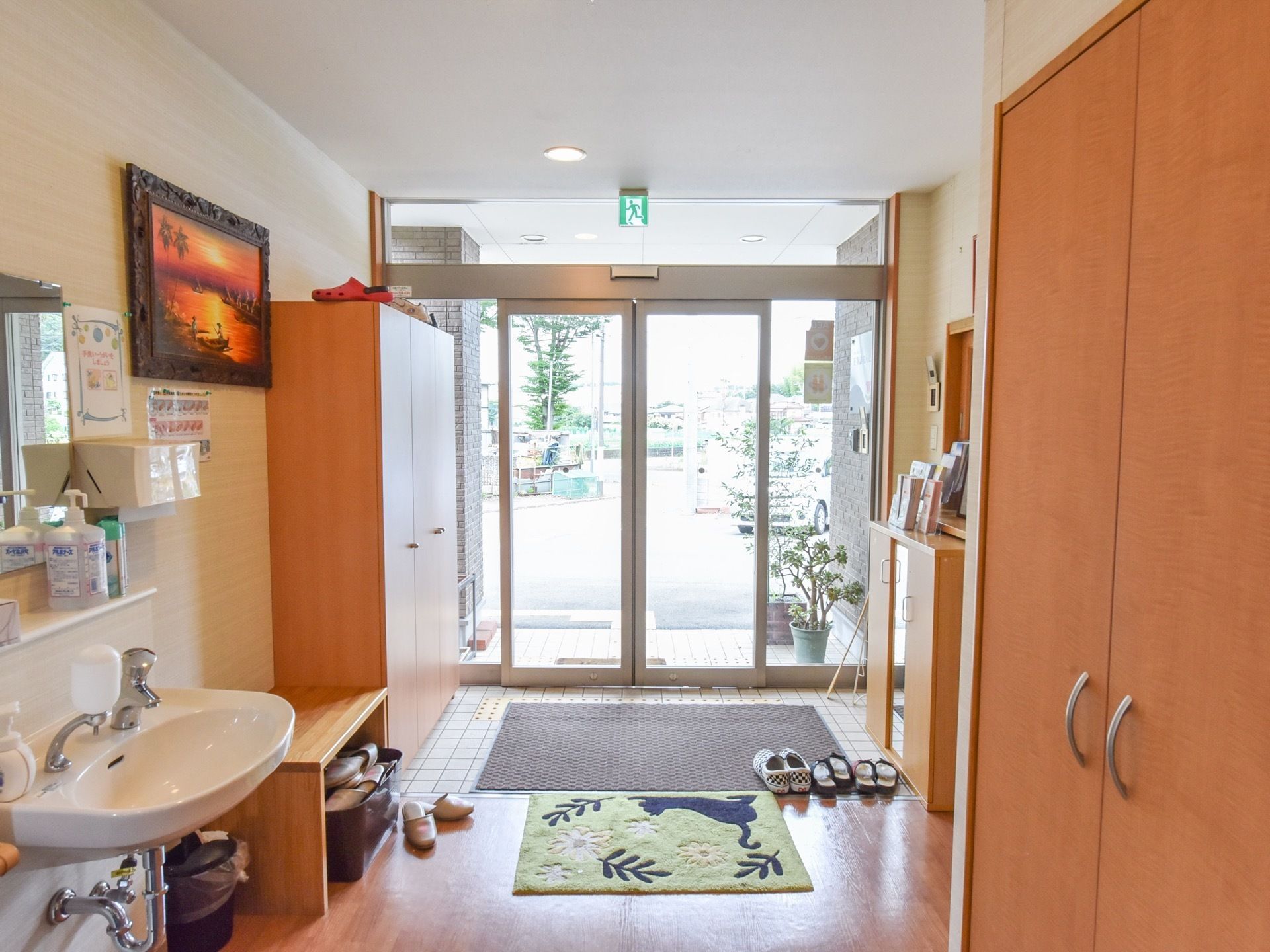 全面ガラスのスライドドアの玄関には誘導灯がありバリアフリーである。大きな下駄箱や飾り棚、洗面台などがある。