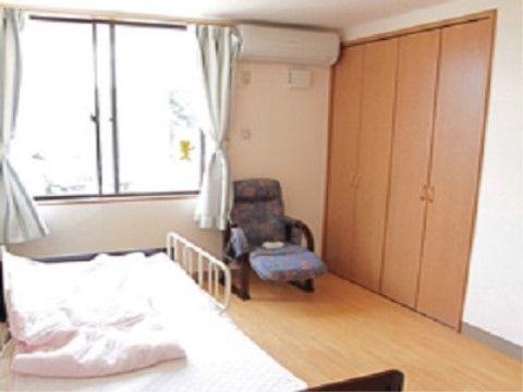 ベッドの向かい側の壁沿いに大きなクローゼットが組み込まれた広い居室