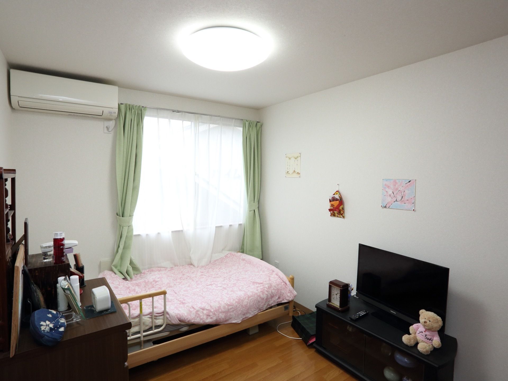窓やエアコンが完備された居室には、テレビや介護用ベッドが設置され、居室内は入居者様のお好みにレイアウトされている。