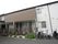 施設は２階建てである。数か所にある窓にはカーテンがかけられている。施設の前にはプランターが並べられている。