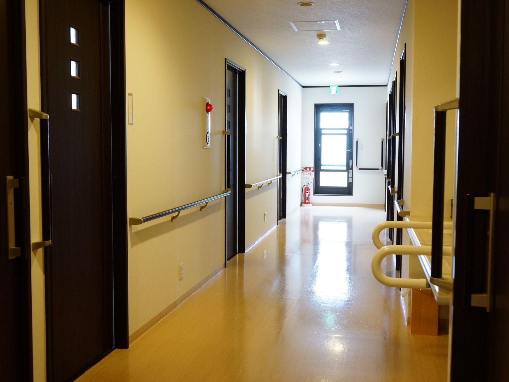 廊下の突き当たりには窓があり、上には非常口を示すサインが付いている。居室のドアは黒色で、三つの小窓がある。