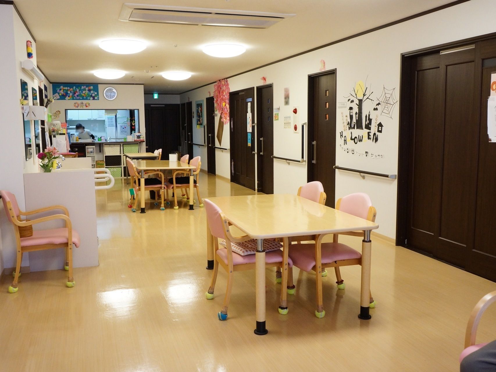 食堂のテーブルには４脚のピンク色の椅子がある。椅子とテーブルには、クッション材を付けて安全性を高めている。