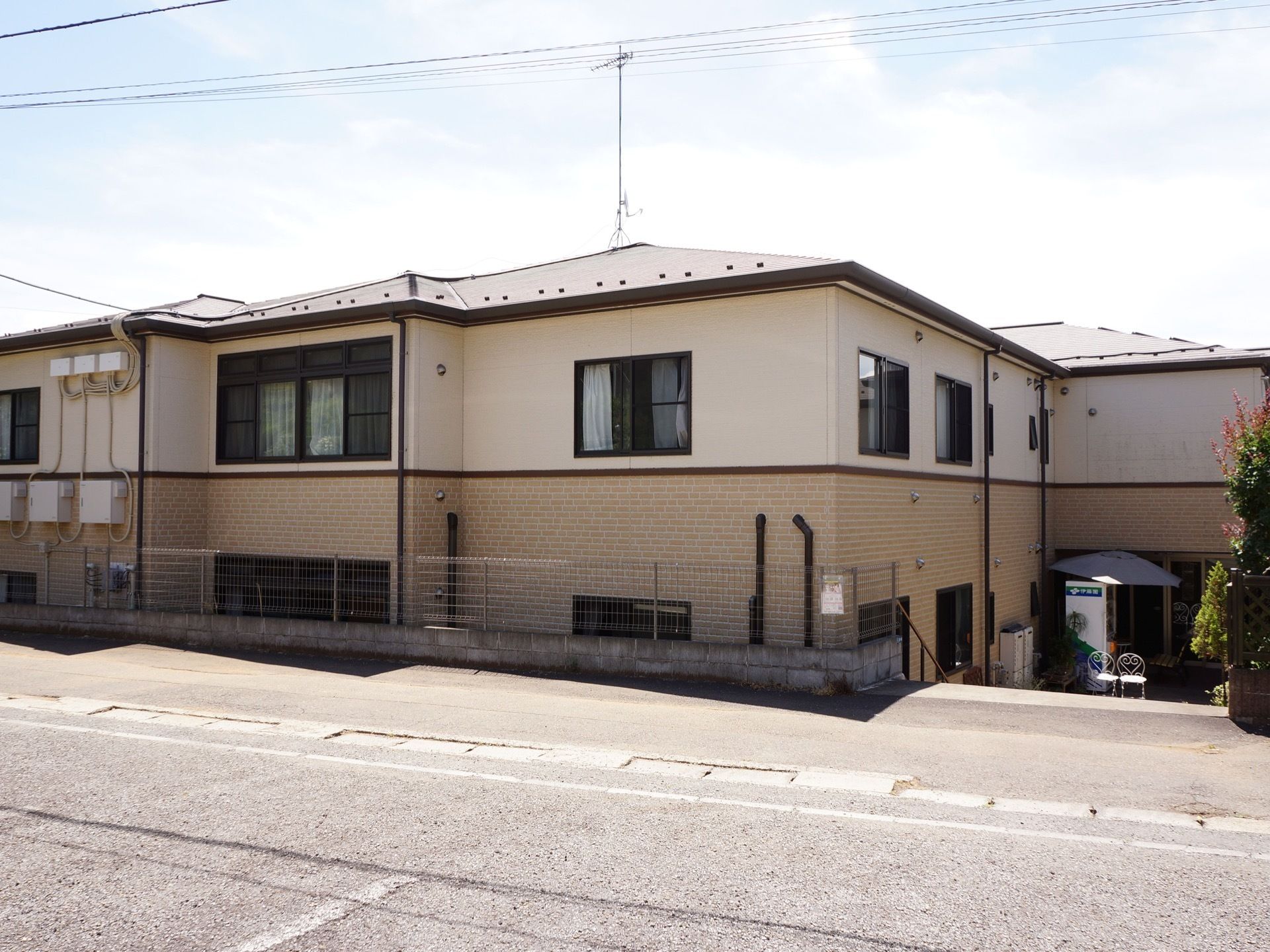 施設の１階はレンガ調の壁を採用している。二階建てであり二階部分は白い壁となっている。入り口付近には自動販売機がある。