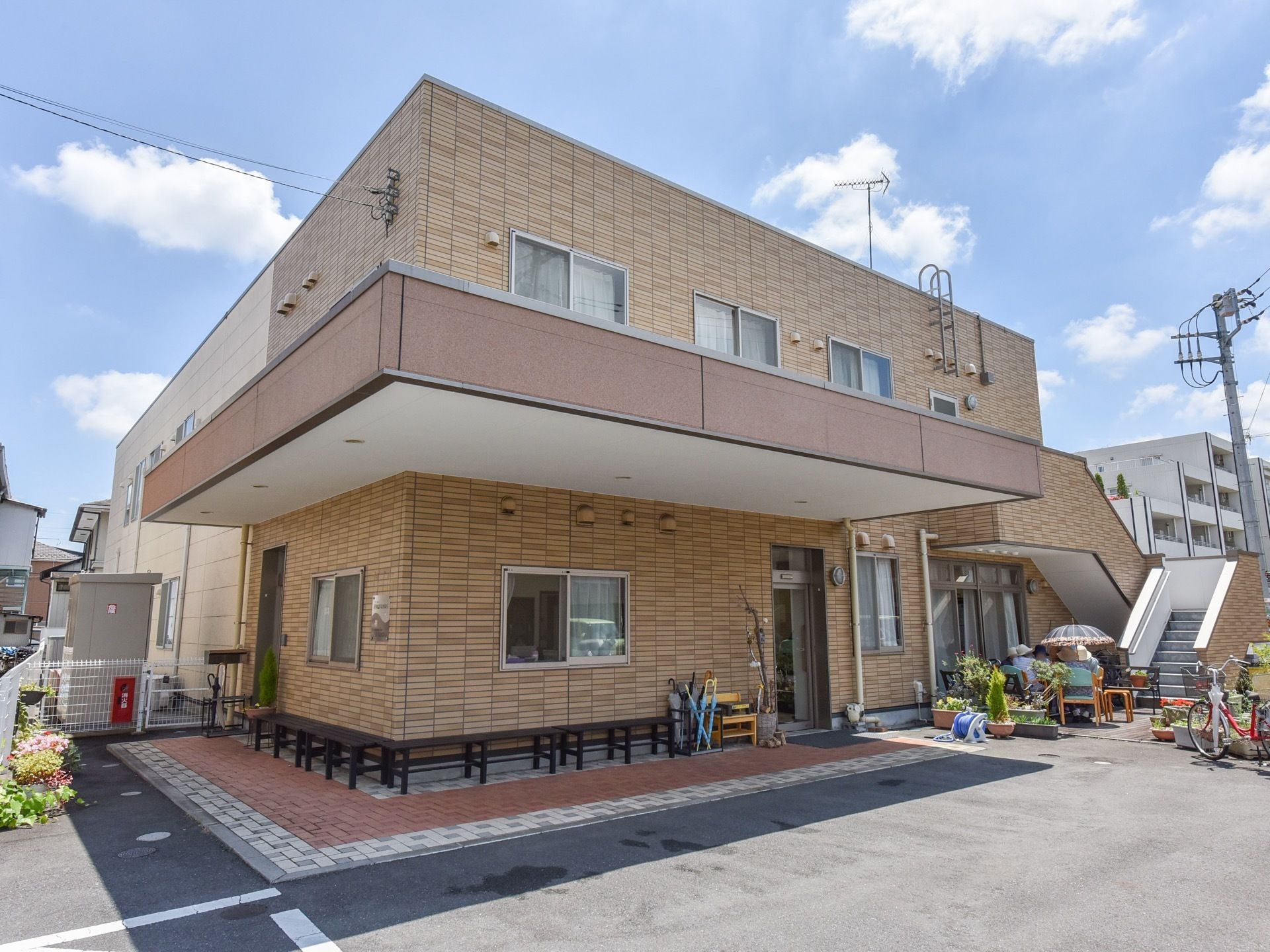 ブラウンが基調の外壁で落ち着いた雰囲気の建物である。建物の周りにはベンチを設置しており、座ってくつろぐことができる。