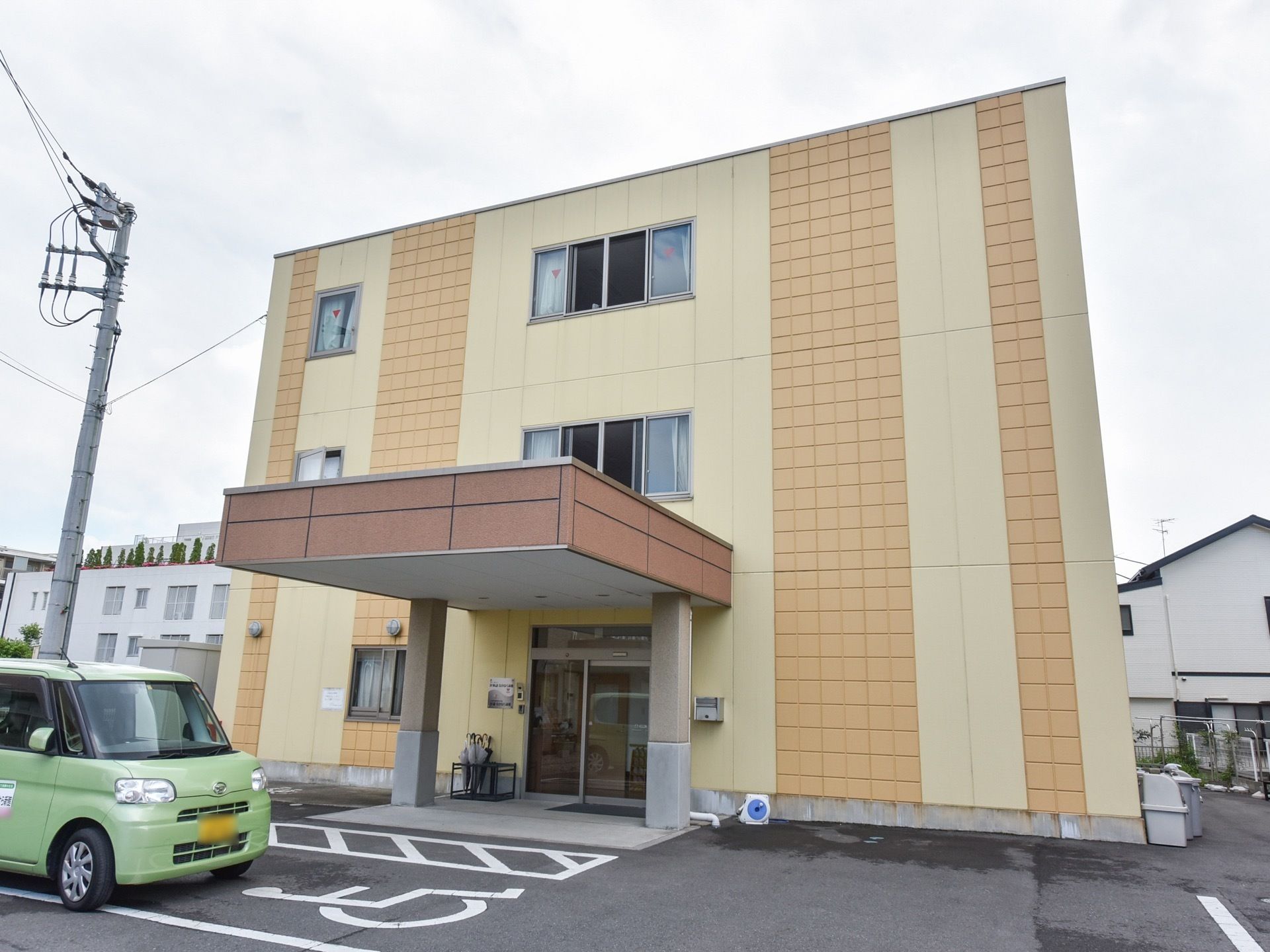 ３階建ての施設で、外壁は黄色とオレンジ色。入口には屋根がある。各階には多くの窓があり、日光の入りも充実している。