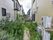 建物前にはウッドデッキがあり、その先にさまざまな種類の植物が植えられている庭がある。中央には小道がある。