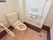 洗浄機能付きの洋式トイレ。トイレットペーパーホルダーは二つ設置されている。壁とトイレの横に手すりが取り付けられている。
