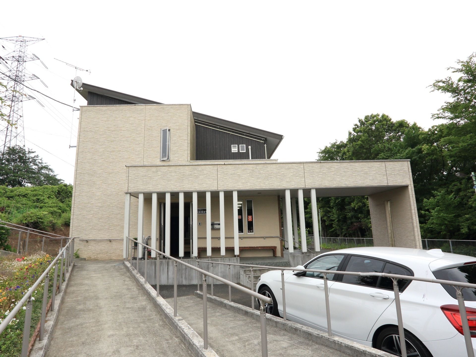 外から玄関にまで続くスロープ付きで、壁には手すりが付いている。玄関の前まで自動車の駐車が可能になっている。