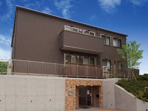 施設の建物は３階建てで、外壁にはベランダが設けられている。１階の玄関には屋根が設けられ、周囲はフラットな設計になっている。