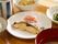 白い皿に焼き魚が入っている。囲むようにお茶と副菜の２皿とごはんに味噌汁のお椀が木目調のトレイの上に並んでいる。