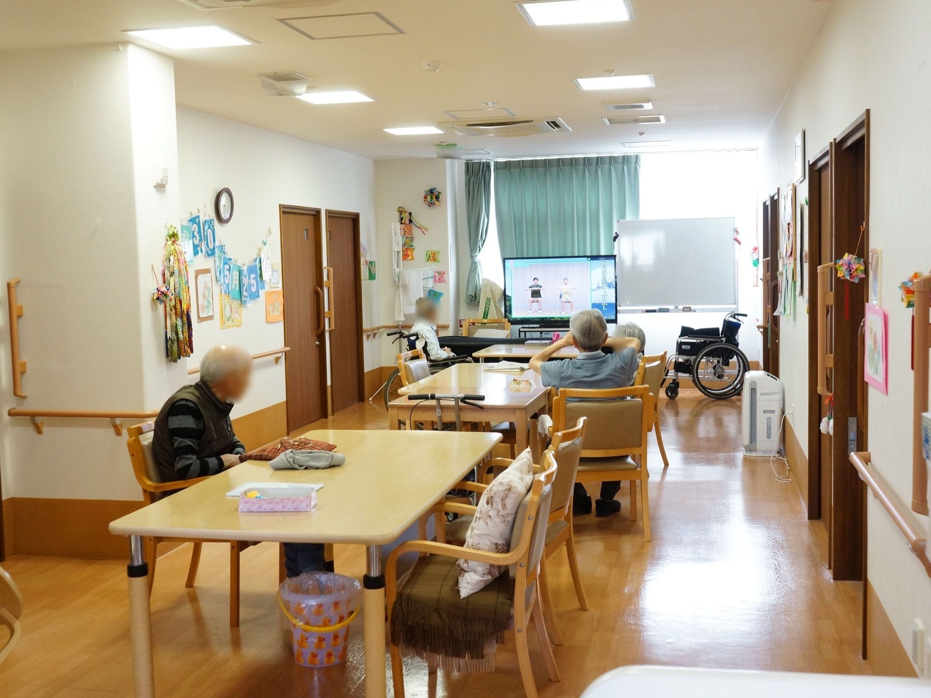 通路の先に縦長の空間がある。その中央に食卓を置き、突き当りにはテレビが設置されている。この食堂は共有スペースとして兼用されている。