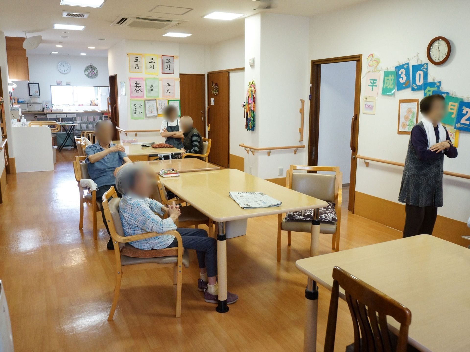 居室の前にあるリビングルームで会話を楽しみながら過ごす入居者