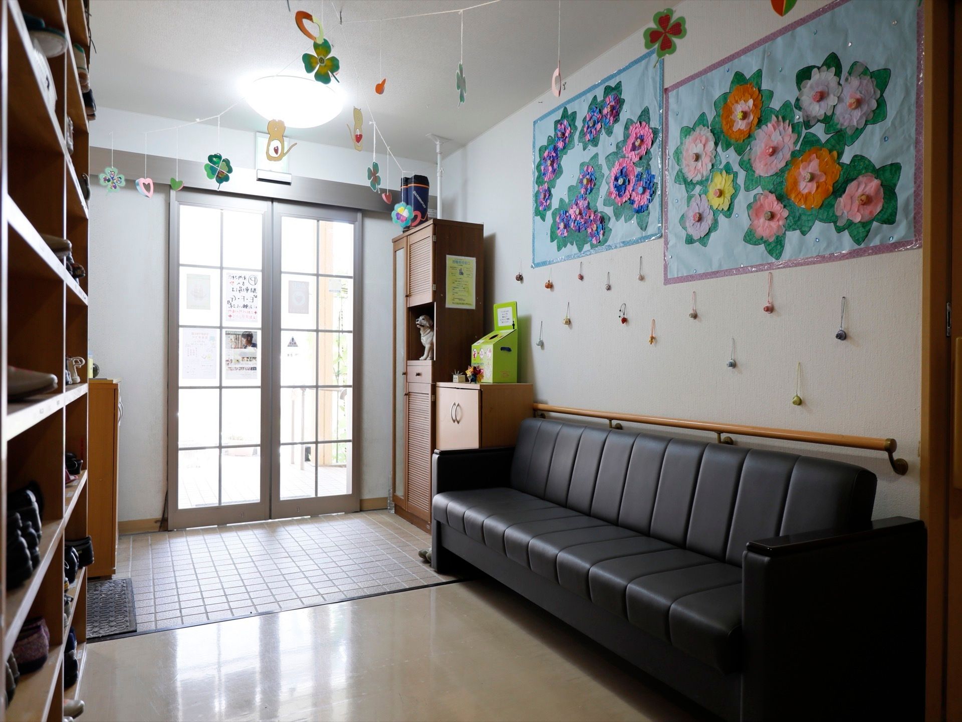 玄関の壁には、カラフルな紙で作った花が貼ってある。また天井にも飾りを付けている。タイルと平らな地面とに分かれている。