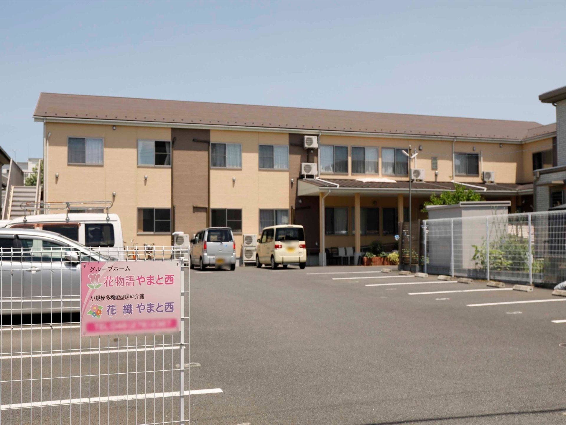 駐車場前の柵には、ホーム名が書いてある表札が掲げられている。駐車場にはラインが引かれており、番号をふっている。