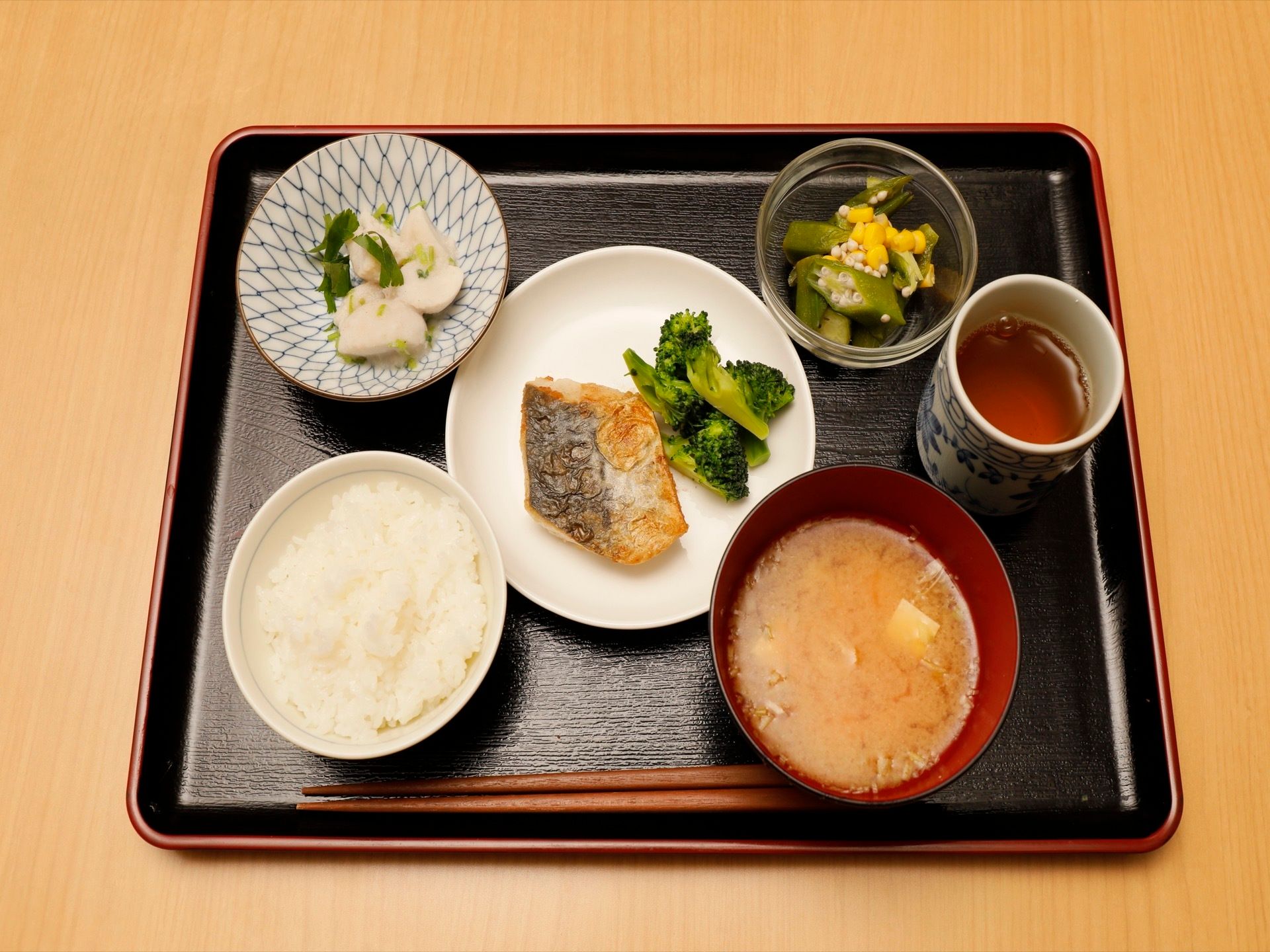 焼き魚と付け合わせ、お味噌汁、漬物、オクラと白米がトレーにのっている。３食の献立は栄養価を考えて作られている。