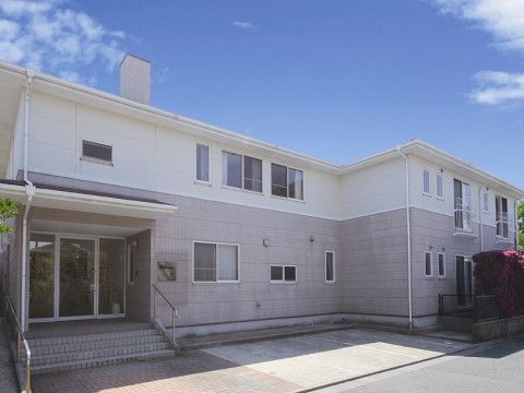 階段を４段上がるとエントランスになるツートンカラーの２階建ての建物