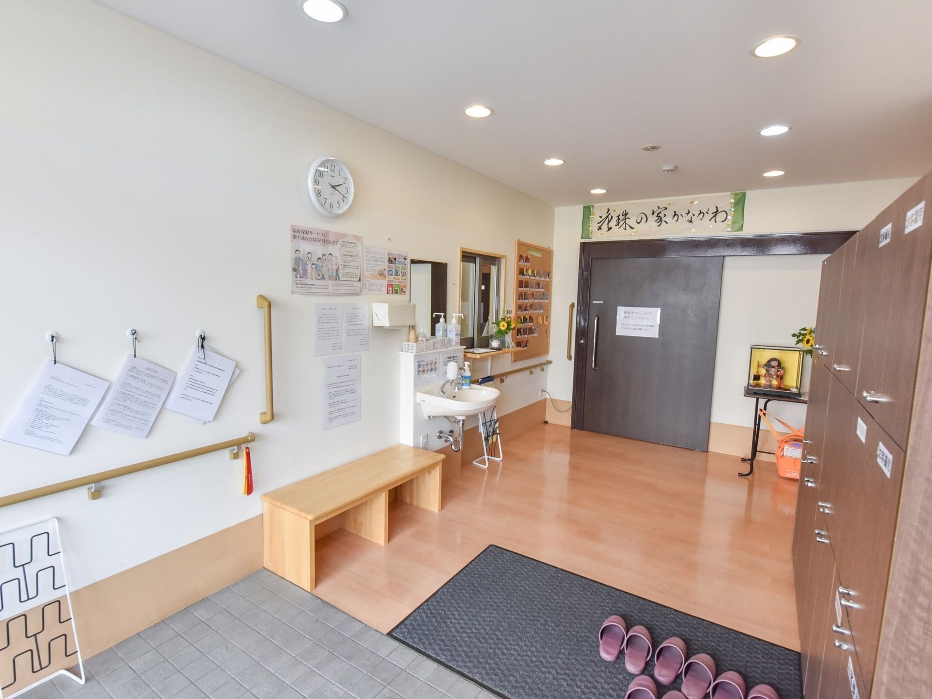 玄関上り口の傍に腰かけ台を設置し、隣に洗面台を備え消毒液やソープなどを置いている。スタッフが常駐する受付窓口を設けている。