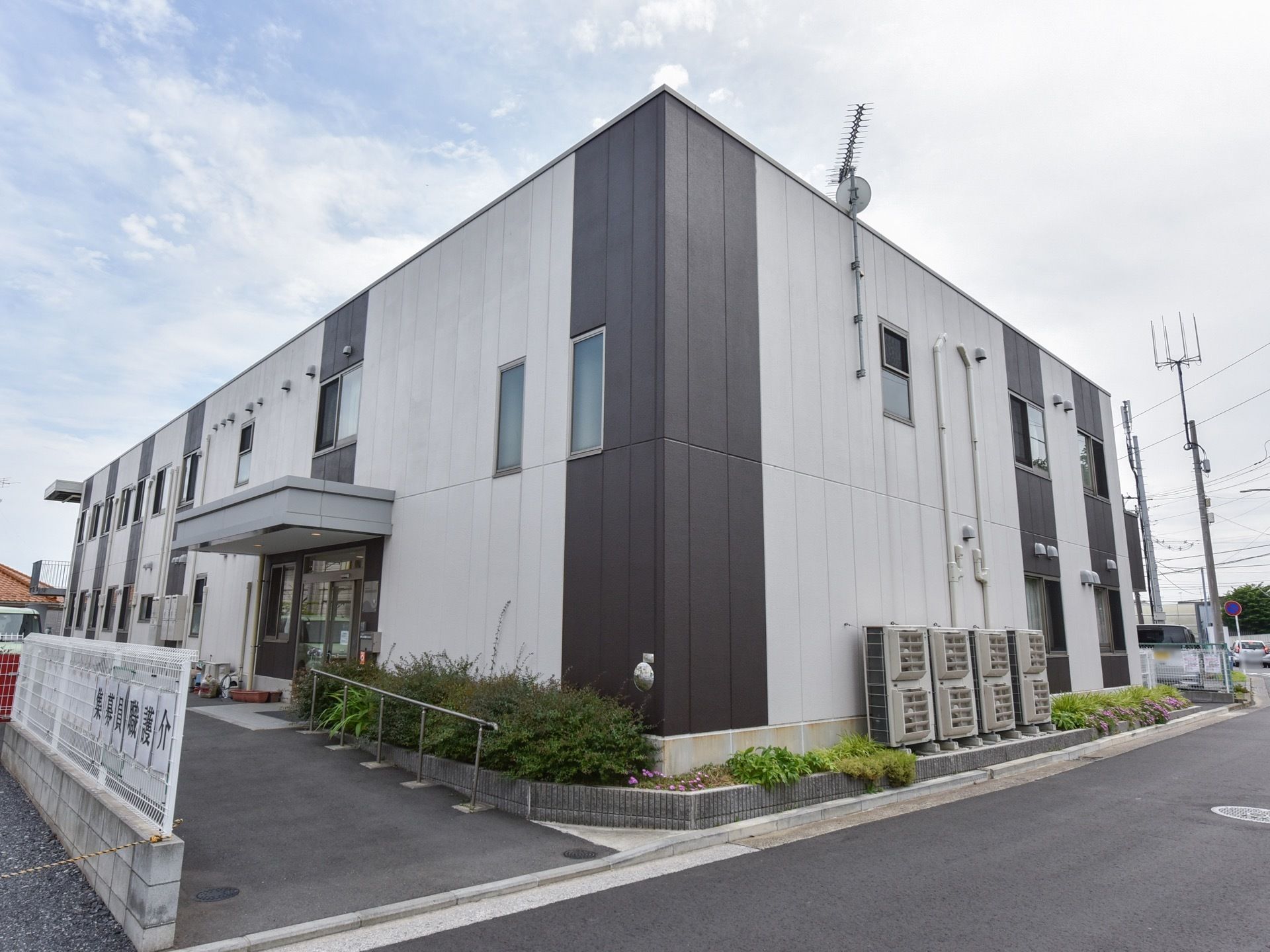 ２階建ての箱型の建物は、シンプルなデザインの外観である。敷地内はアスファルトで舗装し、手すりを備えるなど安全に歩行ができる設備を整えている。