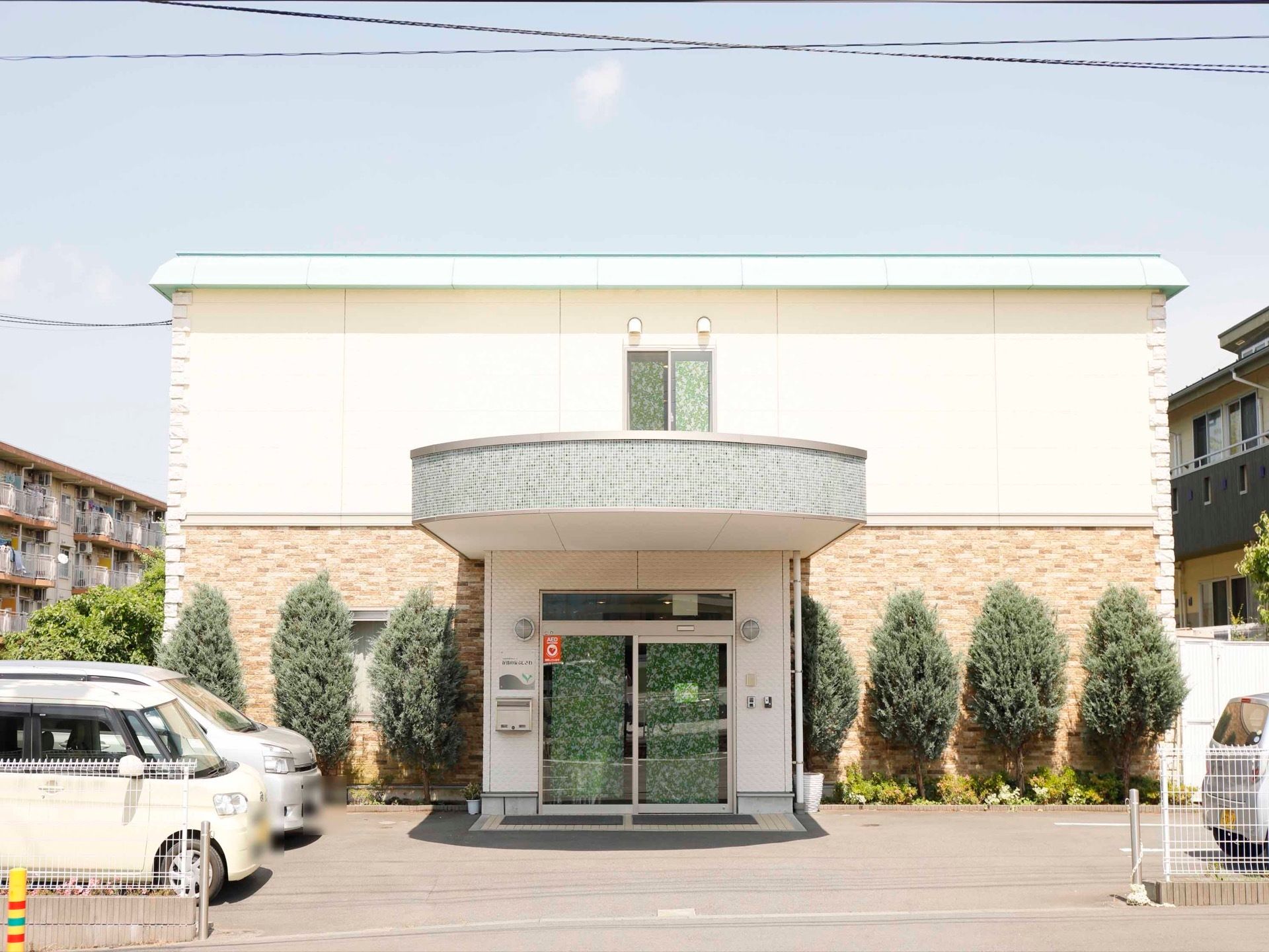 淡いグリーンの屋根のある二階建ての建物で、入口は自動ドアである。建物の前には駐車場が整備されている。