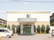 淡いグリーンの屋根のある二階建ての建物で、入口は自動ドアである。建物の前には駐車場が整備されている。