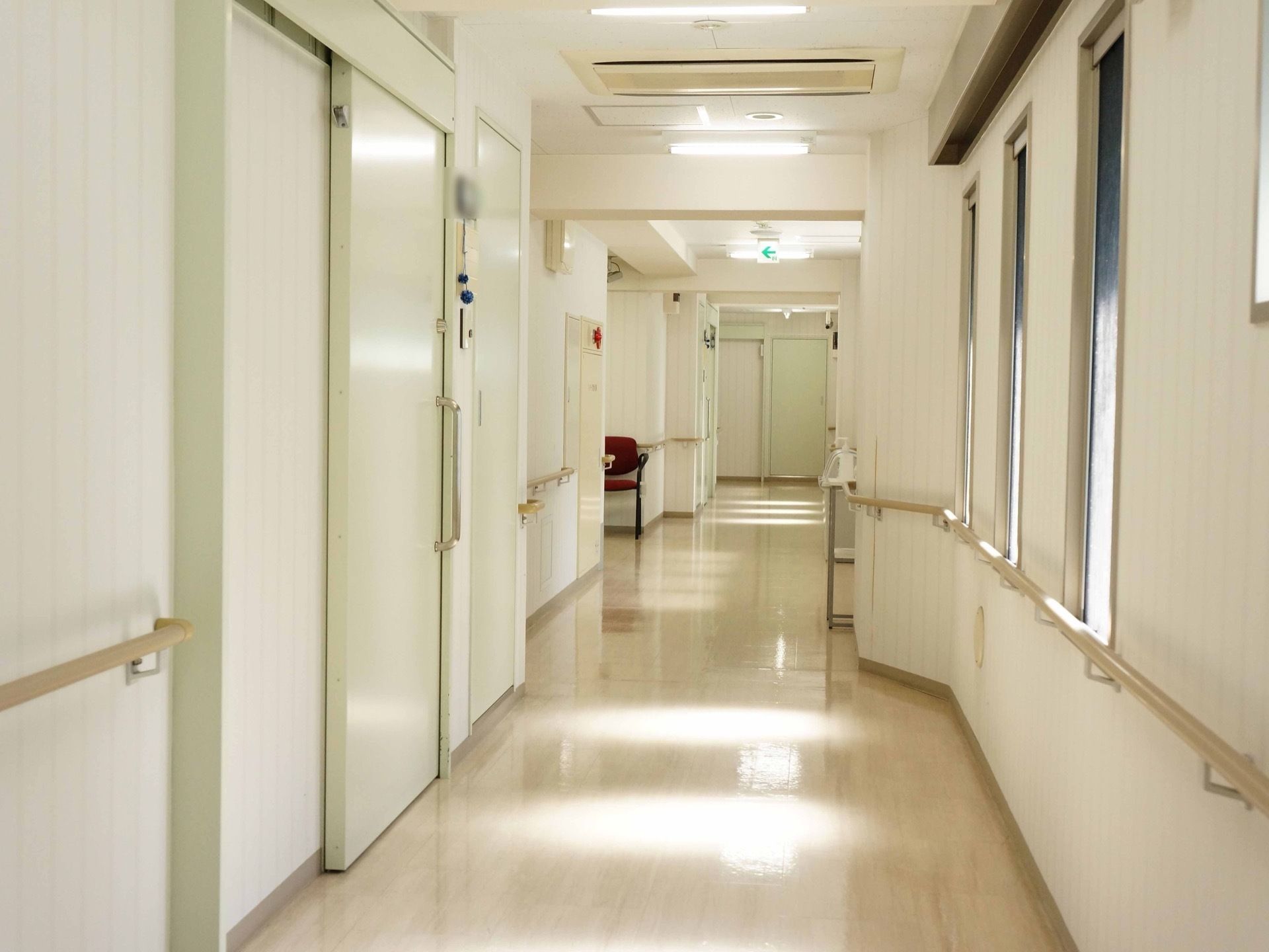 窓がいくつもあり、外からの光が明るい。通路の両側には手すりが設置されている。部屋の扉はスライドタイプとなっている。