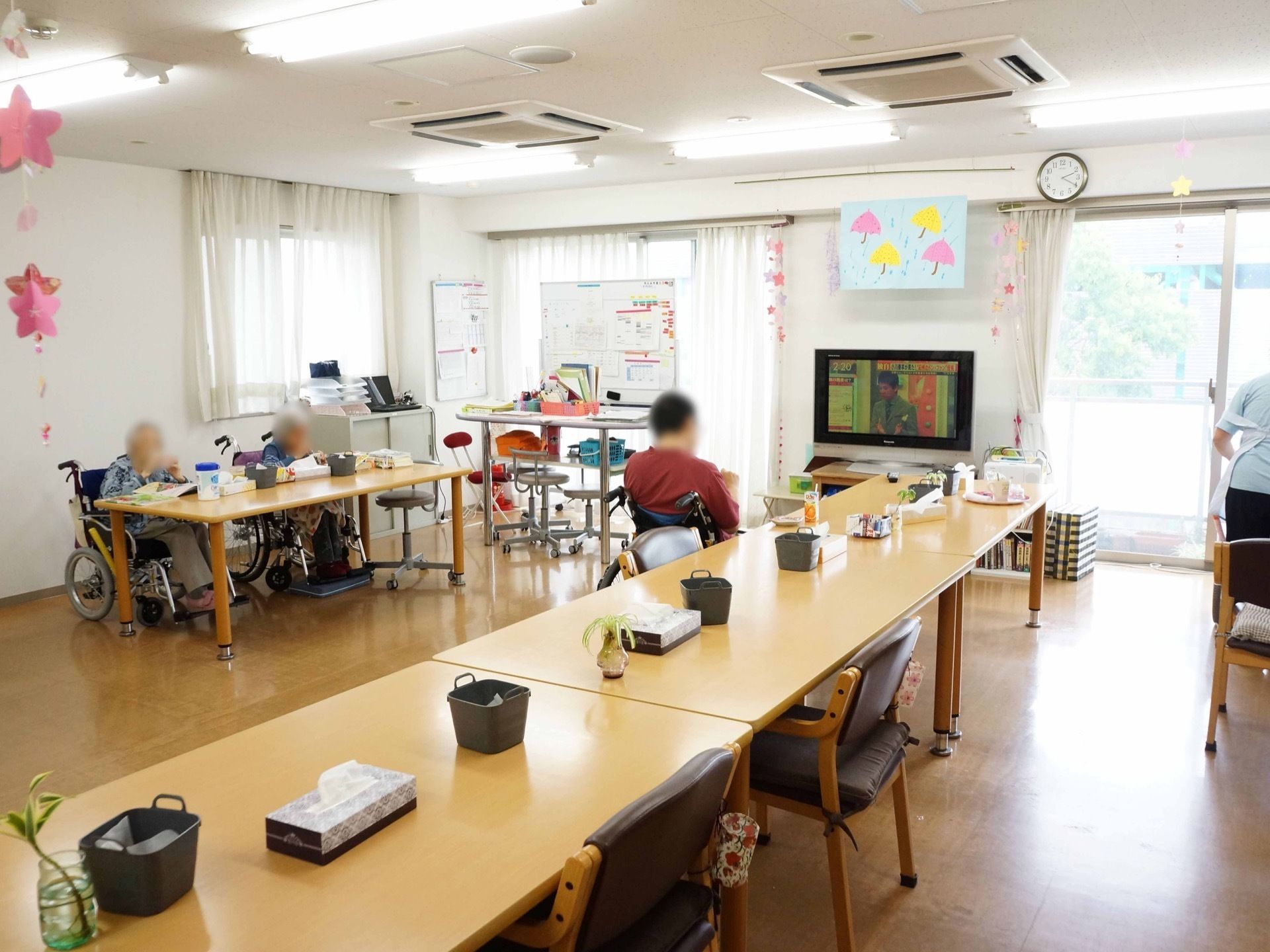 食堂の壁の一面は大きな窓が続いており、明るい自然光がフローリングに反射している。各テーブルの上にはティッシュ箱が備わっている。
