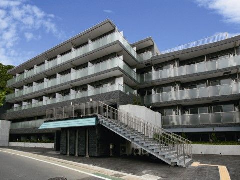 サービス付き高齢者向け住宅ゆりがおか療養センターの外観。大きなマンションのような施設外観。来訪者様用の駐車スペースをご用意しております。
