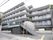 ５階建ての建物で、グレーの落ち着いた外観である。各階にベランダがあり、二階へは手すりのついた長い階段がある。