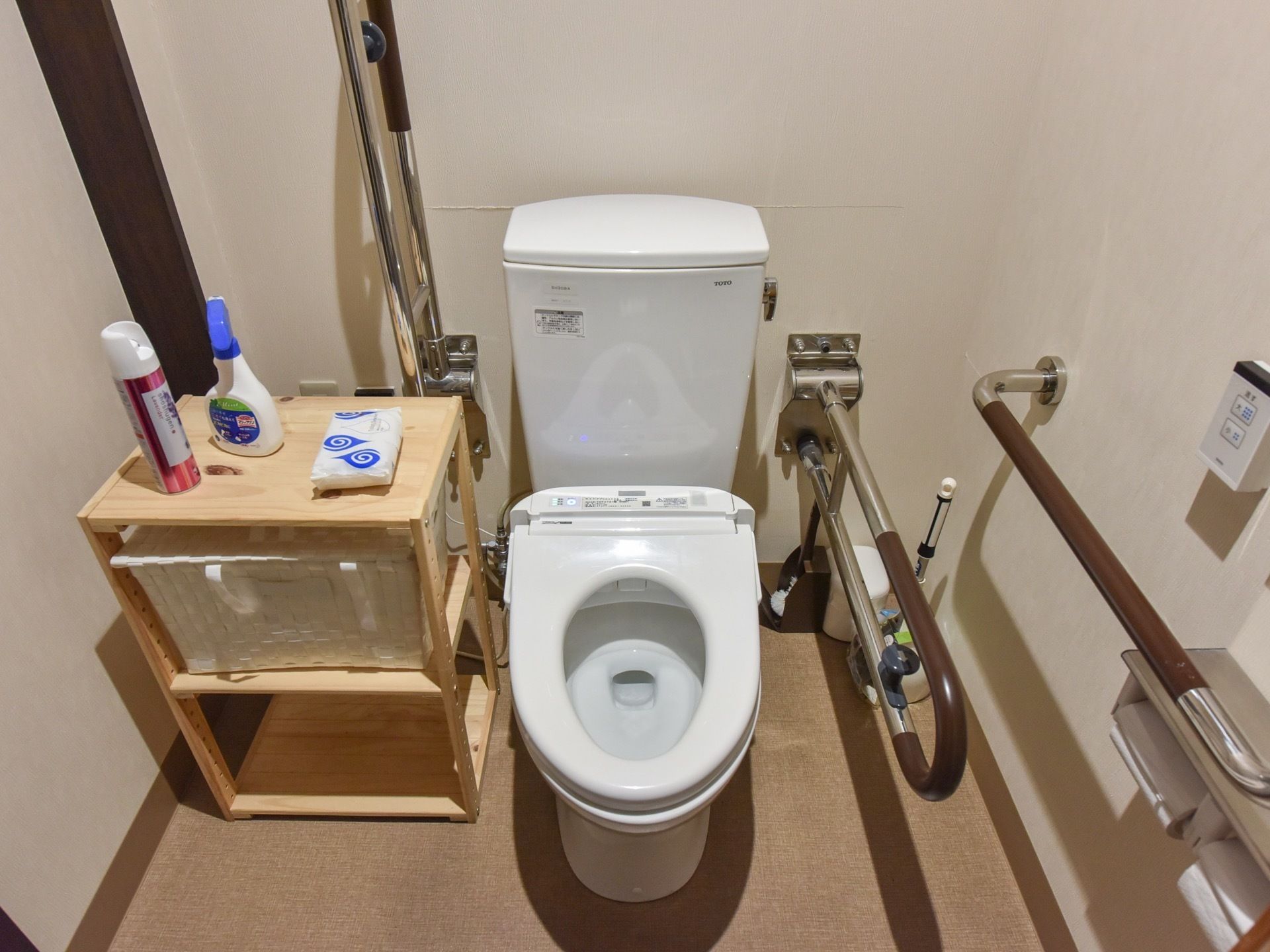 トイレの便器はきれいに磨かれており、便座の蓋は取り払われている。また、周囲の壁には手すりが複数取り付けられている。
