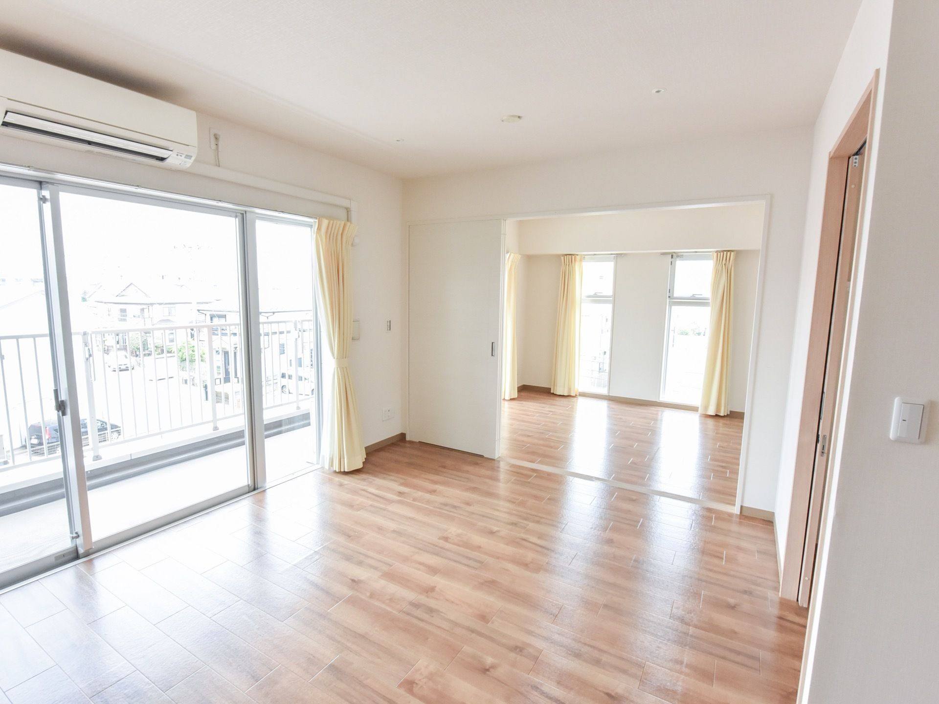 居室は複数の部屋が連結した形になっている。大きな窓からはベランダに出られ、その上にはエアコンが設置されている。
